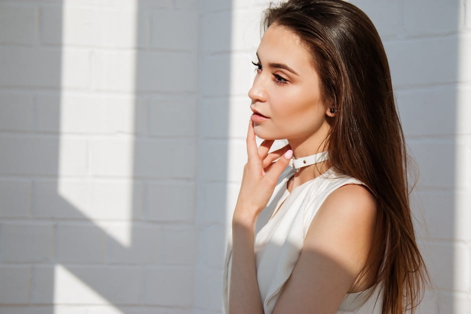 Natural light portrait of a stylish woman posing indoors with a pensive expression.